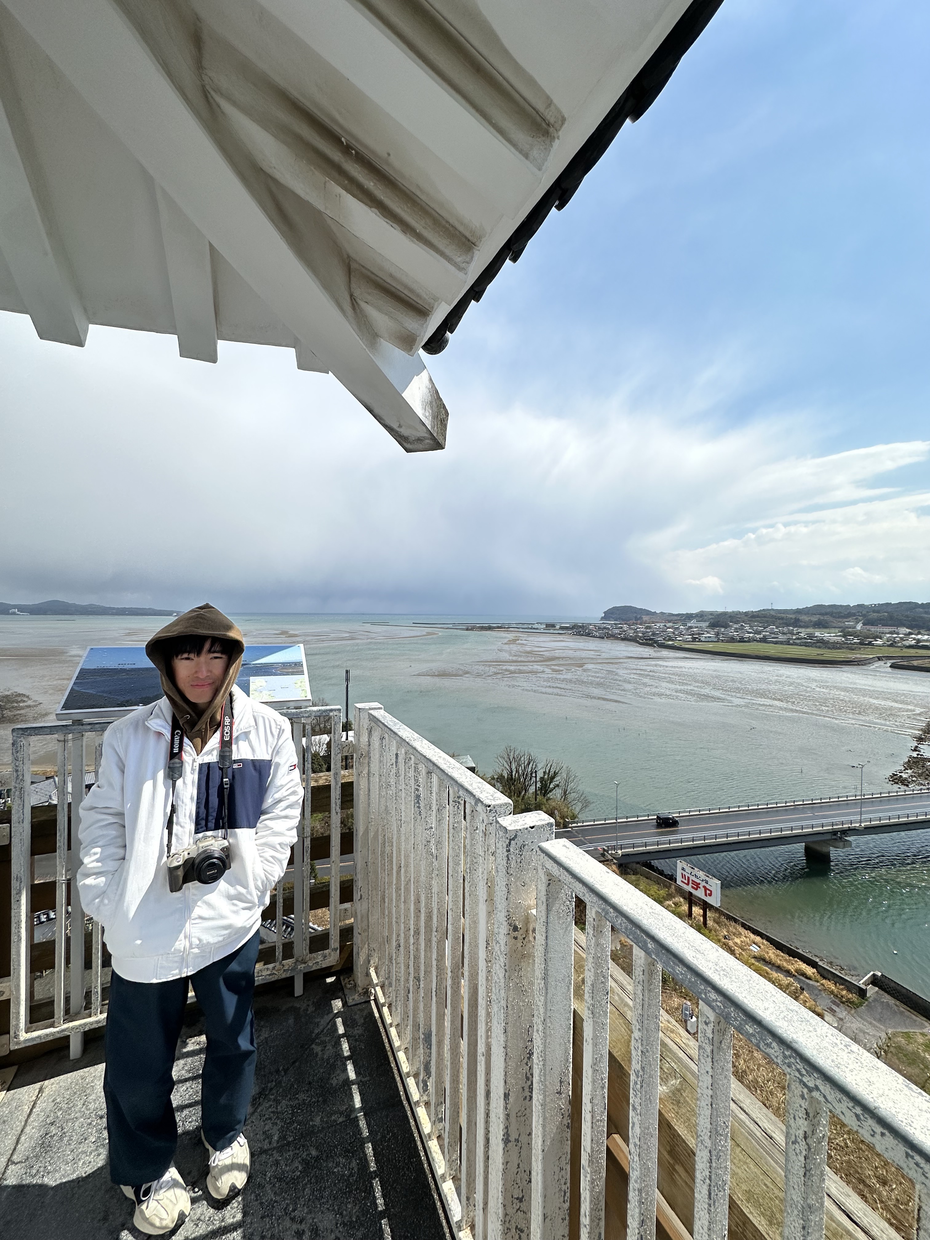 Duchan holding his camera under a blue sky.